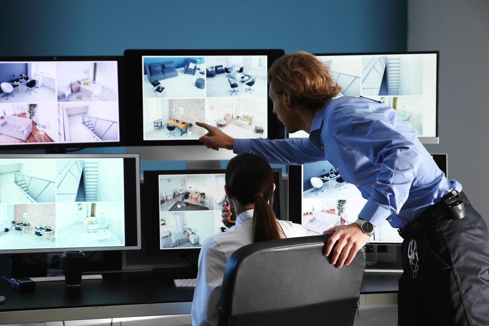 Security guards monitoring modern CCTV cameras in surveillance r